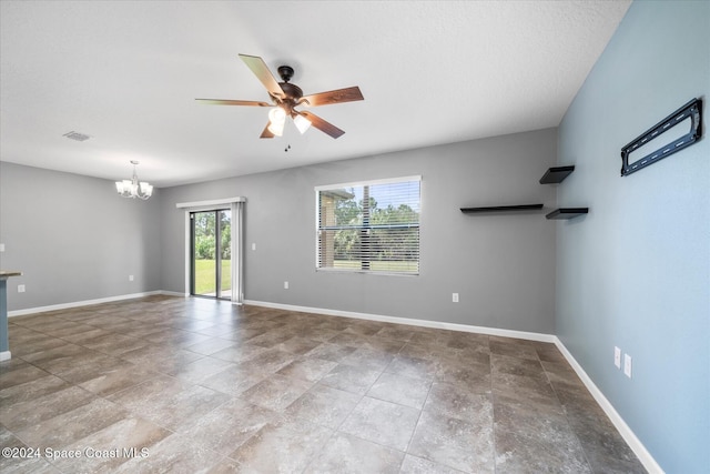 empty room featuring a textured ceiling, a healthy amount of sunlight, and ceiling fan with notable chandelier