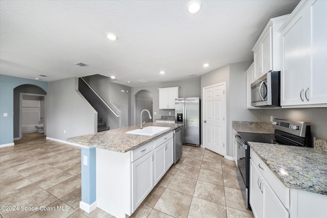 kitchen with a kitchen island with sink, appliances with stainless steel finishes, white cabinetry, and sink