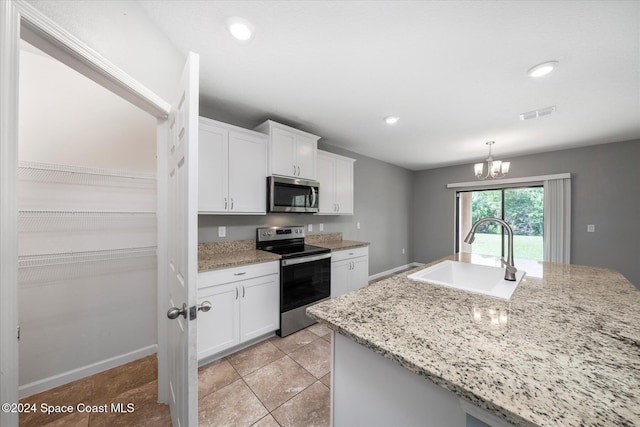 kitchen featuring white cabinets, stainless steel appliances, sink, and light stone counters