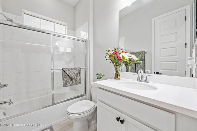 full bathroom featuring bath / shower combo with glass door, vanity, and toilet