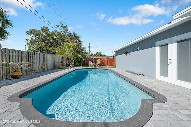 view of swimming pool featuring french doors and a patio area