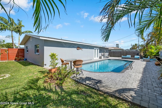 view of pool with a patio area and a yard