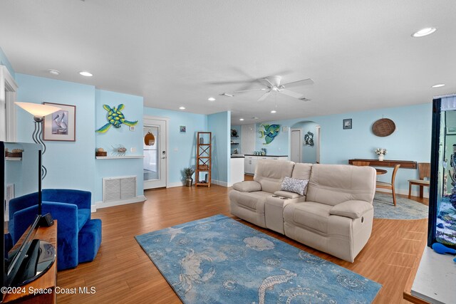 living room with ceiling fan and light hardwood / wood-style flooring