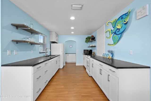 kitchen featuring white cabinets, white appliances, light hardwood / wood-style floors, and sink