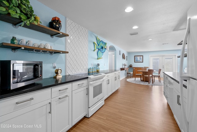 kitchen with french doors, white cabinets, light hardwood / wood-style flooring, a textured ceiling, and white range with electric stovetop