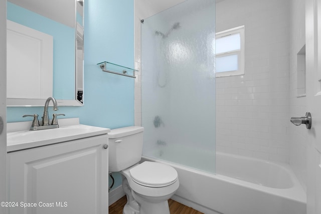 full bathroom featuring vanity, wood-type flooring, tiled shower / bath combo, and toilet