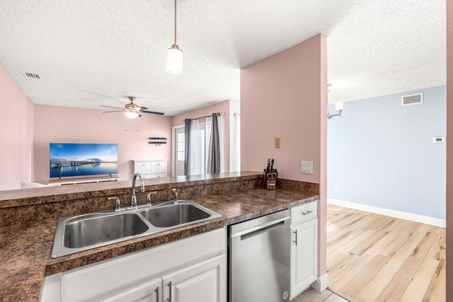 kitchen featuring a textured ceiling, ceiling fan, sink, dishwasher, and white cabinetry