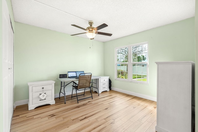 home office featuring a textured ceiling, light hardwood / wood-style floors, and ceiling fan