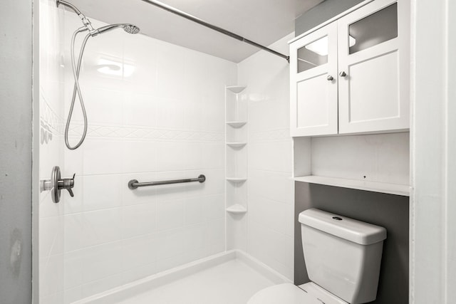 bathroom with toilet and a tile shower