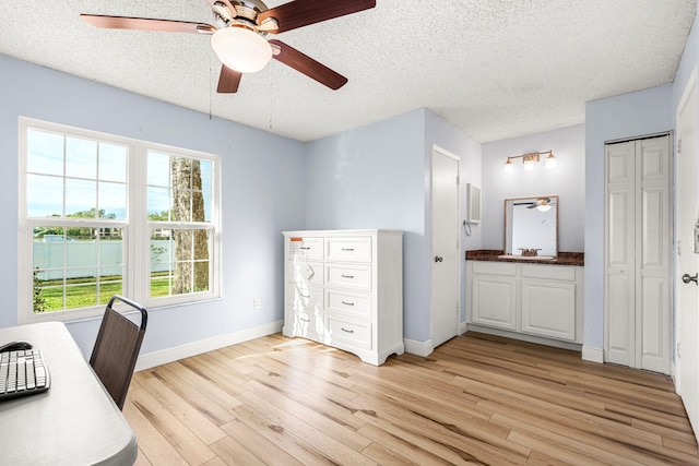 unfurnished office featuring a textured ceiling, light hardwood / wood-style floors, and sink