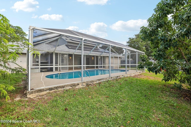 view of swimming pool featuring a lawn and a lanai