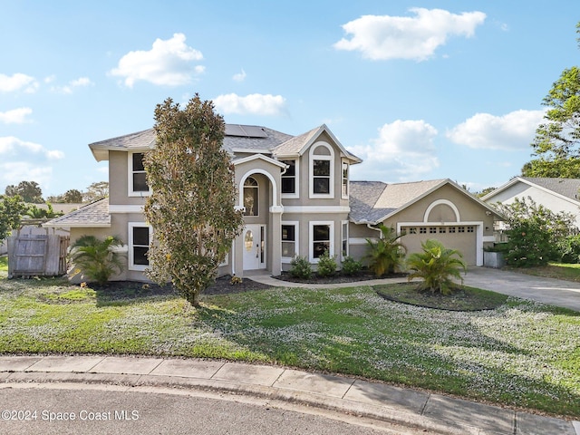 view of front of house featuring solar panels, a garage, and a front yard