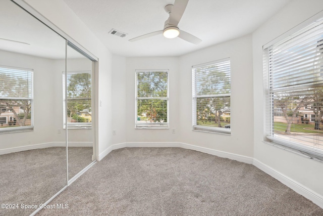 carpeted spare room featuring ceiling fan