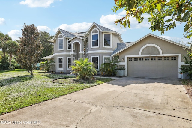 view of property with a front lawn and a garage