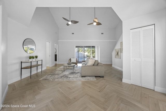 unfurnished living room featuring high vaulted ceiling, light parquet floors, and ceiling fan