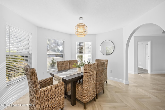 dining area featuring light parquet floors and a chandelier