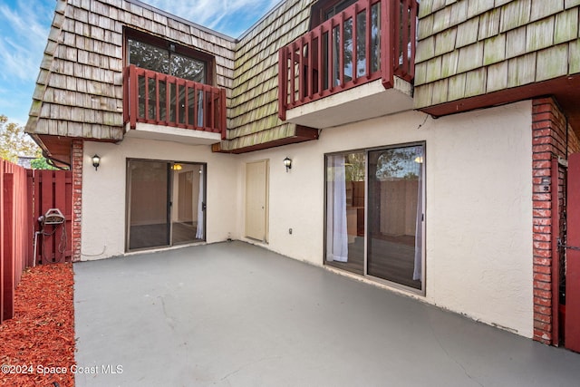 rear view of property featuring a patio area and a balcony