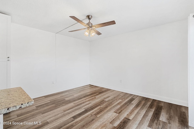 empty room featuring hardwood / wood-style floors, ceiling fan, and a textured ceiling