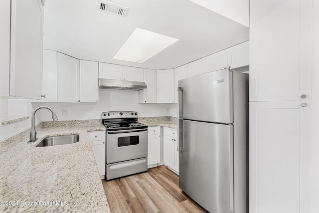 kitchen featuring white cabinetry, sink, light stone counters, appliances with stainless steel finishes, and light wood-type flooring