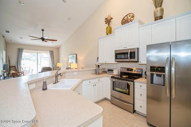 kitchen with stainless steel appliances, ceiling fan, sink, white cabinets, and lofted ceiling