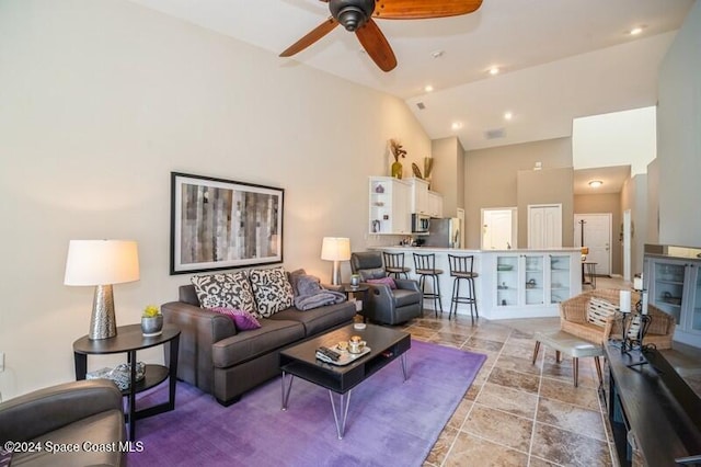 living room featuring ceiling fan and high vaulted ceiling