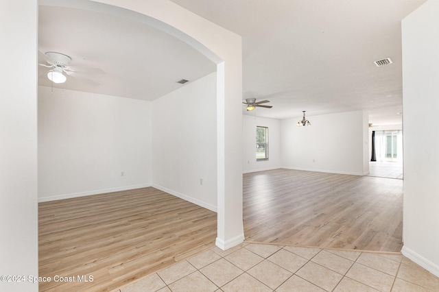 unfurnished room featuring light hardwood / wood-style floors and ceiling fan with notable chandelier