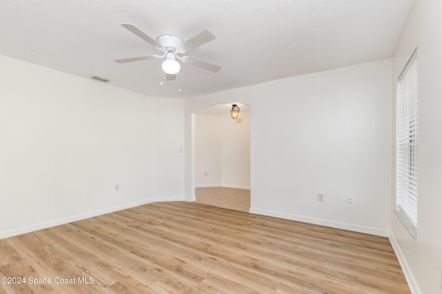 spare room featuring a textured ceiling, light hardwood / wood-style floors, and ceiling fan