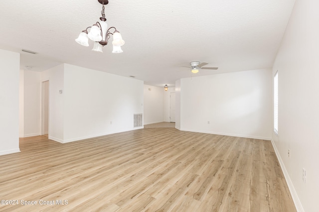 spare room with light wood-type flooring, a textured ceiling, and ceiling fan with notable chandelier