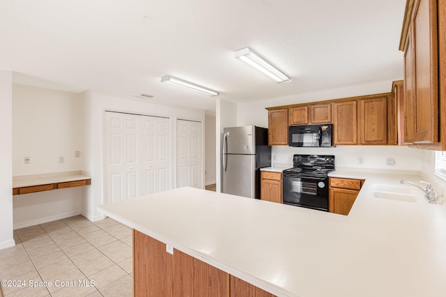 kitchen with kitchen peninsula, black appliances, sink, and light tile patterned floors