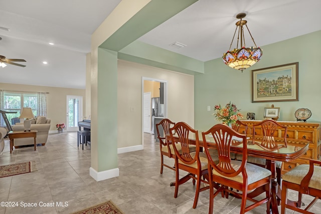 tiled dining room featuring ceiling fan and vaulted ceiling