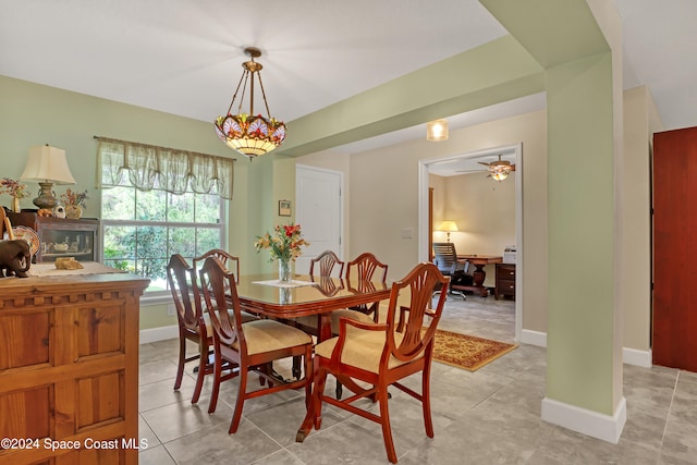 tiled dining space featuring ceiling fan