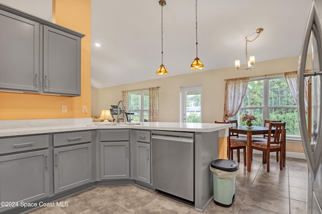 kitchen with kitchen peninsula, gray cabinets, stainless steel appliances, decorative light fixtures, and sink