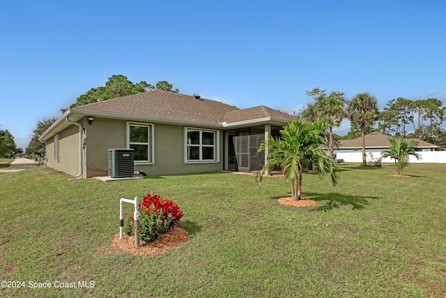 back of property featuring central AC unit and a lawn