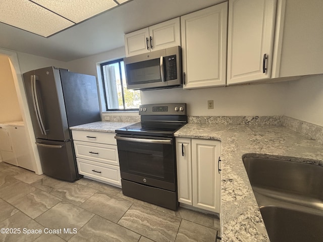 kitchen featuring white cabinetry, sink, stainless steel appliances, and light stone countertops