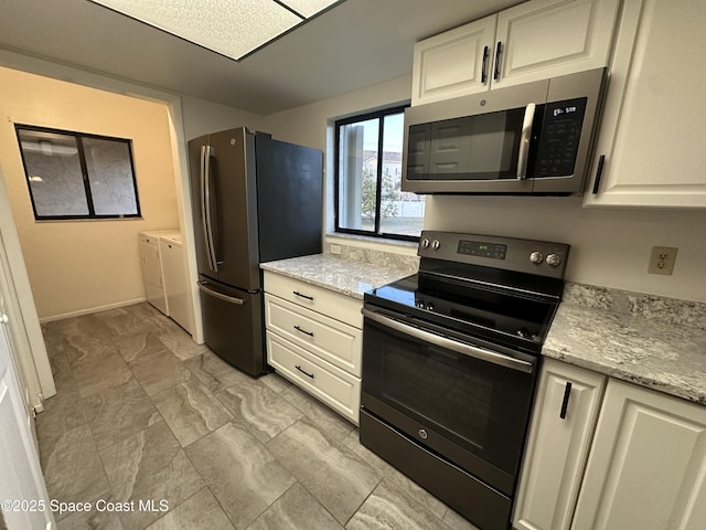 kitchen featuring white cabinetry, stainless steel appliances, and light stone countertops