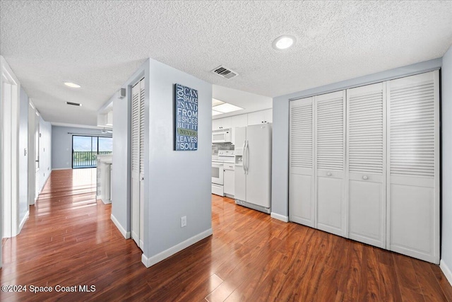 hall with hardwood / wood-style floors and a textured ceiling