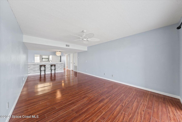 unfurnished living room with hardwood / wood-style floors, a textured ceiling, and ceiling fan