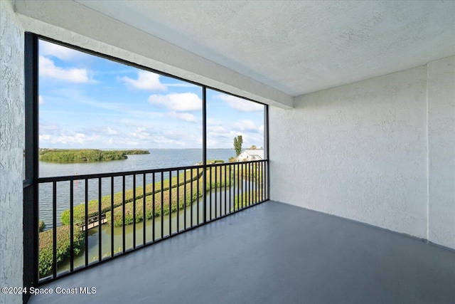 unfurnished sunroom featuring a water view