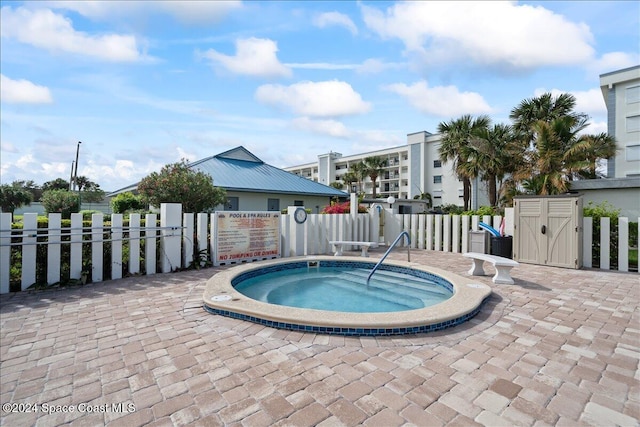 view of swimming pool with a hot tub