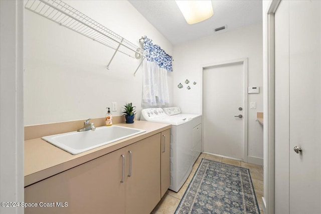 laundry area featuring cabinets, light tile patterned floors, separate washer and dryer, and sink