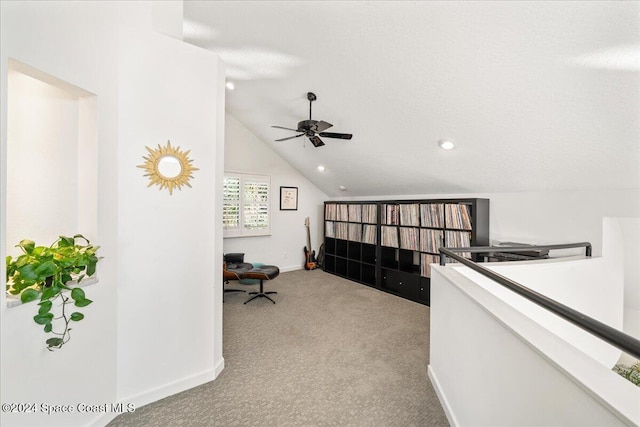 carpeted office space featuring a textured ceiling, ceiling fan, and vaulted ceiling