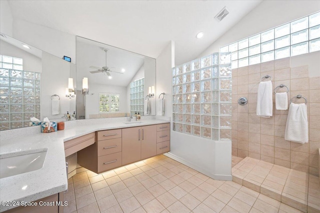 bathroom with vanity, vaulted ceiling, tile patterned flooring, ceiling fan, and tiled shower