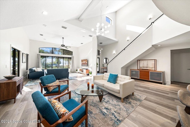 living room featuring ceiling fan with notable chandelier, light wood-type flooring, and high vaulted ceiling