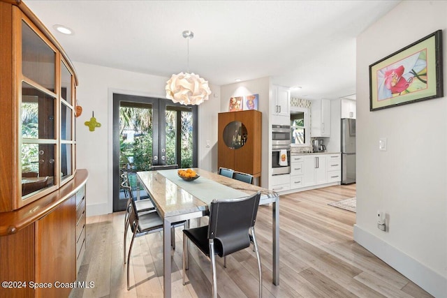 dining area featuring a chandelier, french doors, and light hardwood / wood-style floors