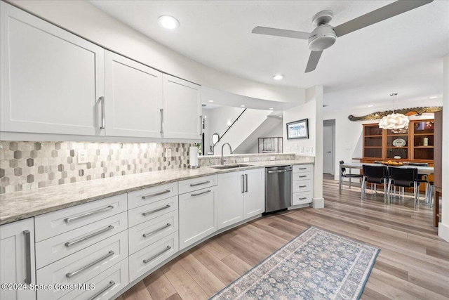 kitchen featuring light hardwood / wood-style floors, white cabinetry, stainless steel dishwasher, and sink