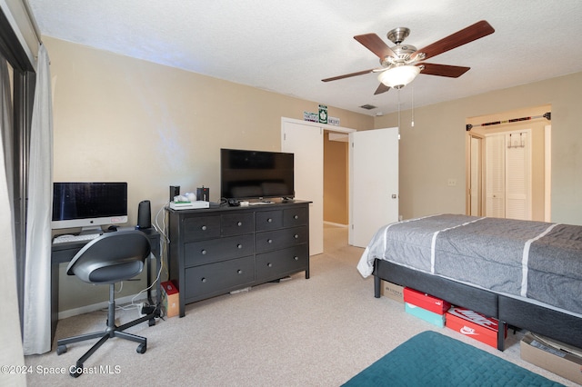 carpeted bedroom featuring a textured ceiling and ceiling fan