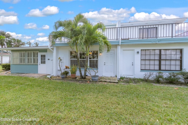 204 Queens Ct, Satellite Beach, FL 32937 - view of front of house featuring a front lawn, a balcony, and stucco siding