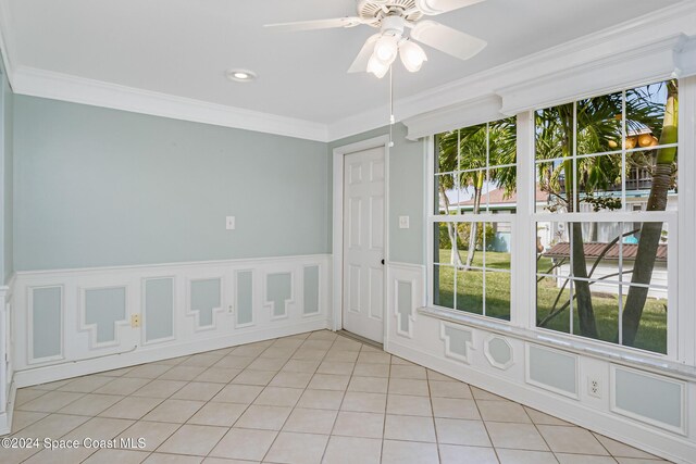 204 Queens Ct, Satellite Beach, FL 32937 - spare room with plenty of natural light, crown molding, a ceiling fan, light tile patterned floors, and a wainscoted wall
