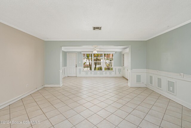 204 Queens Ct, Satellite Beach, FL 32937 - empty room featuring a decorative wall, crown molding, ceiling fan, a textured ceiling, and light tile patterned floors
