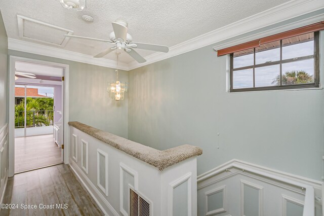 204 Queens Ct, Satellite Beach, FL 32937 - corridor with a textured ceiling, wood finished floors, crown molding, a wainscoted wall, and attic access